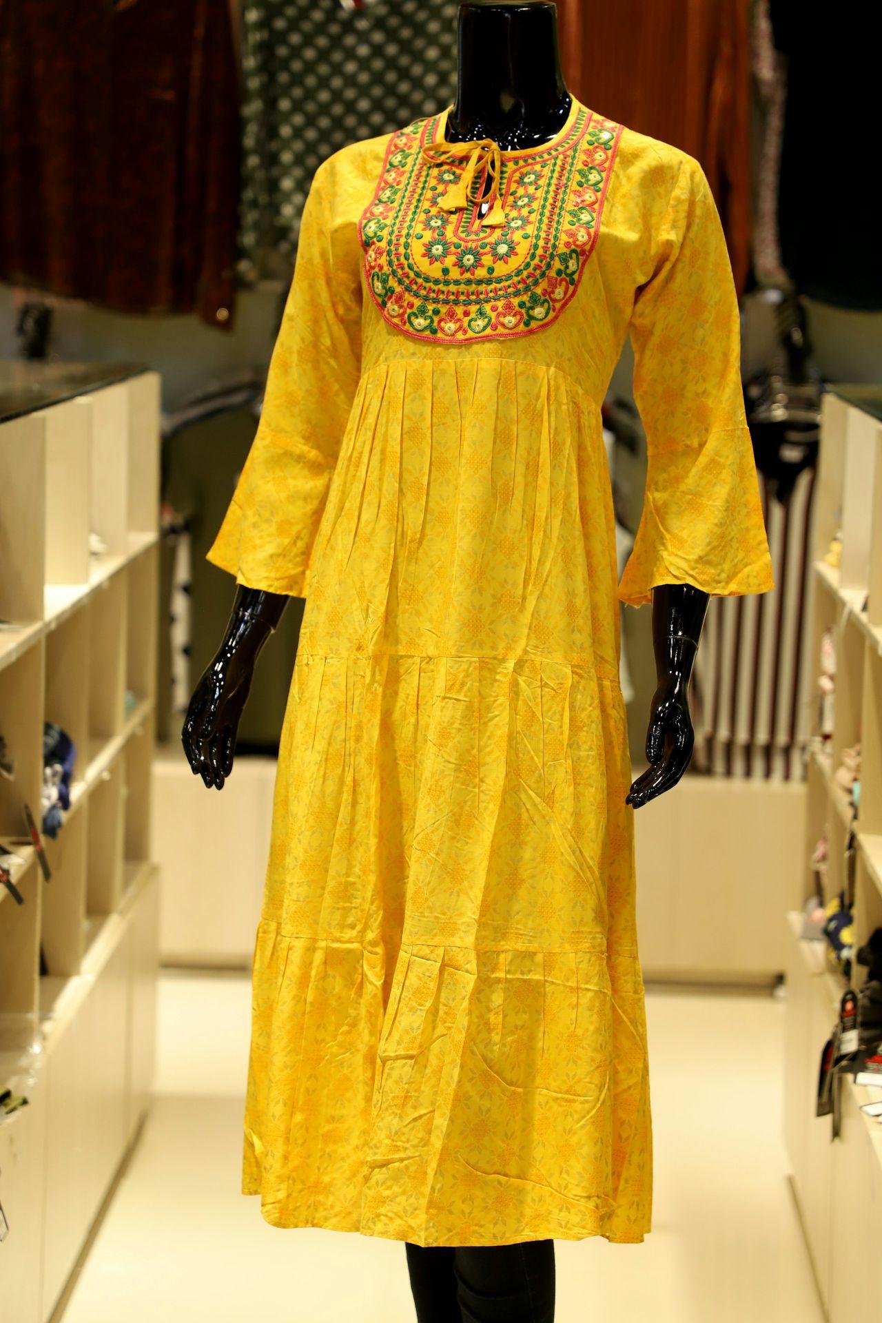 A yellow tiered dress with embroidered neckline